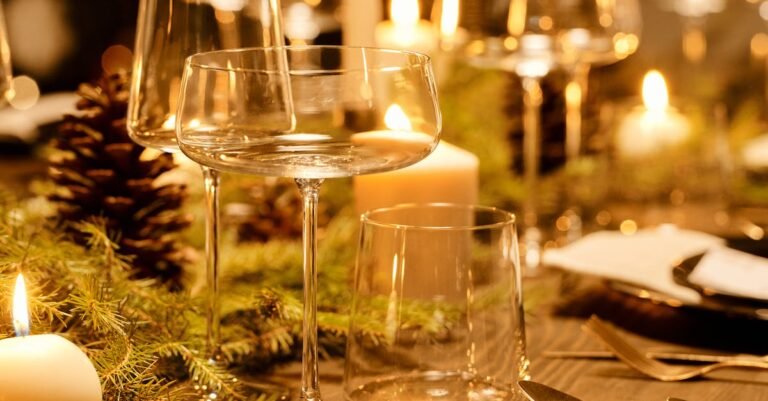 Warm and elegant Christmas dinner table decorated with candles and greenery, perfect for the holiday season.